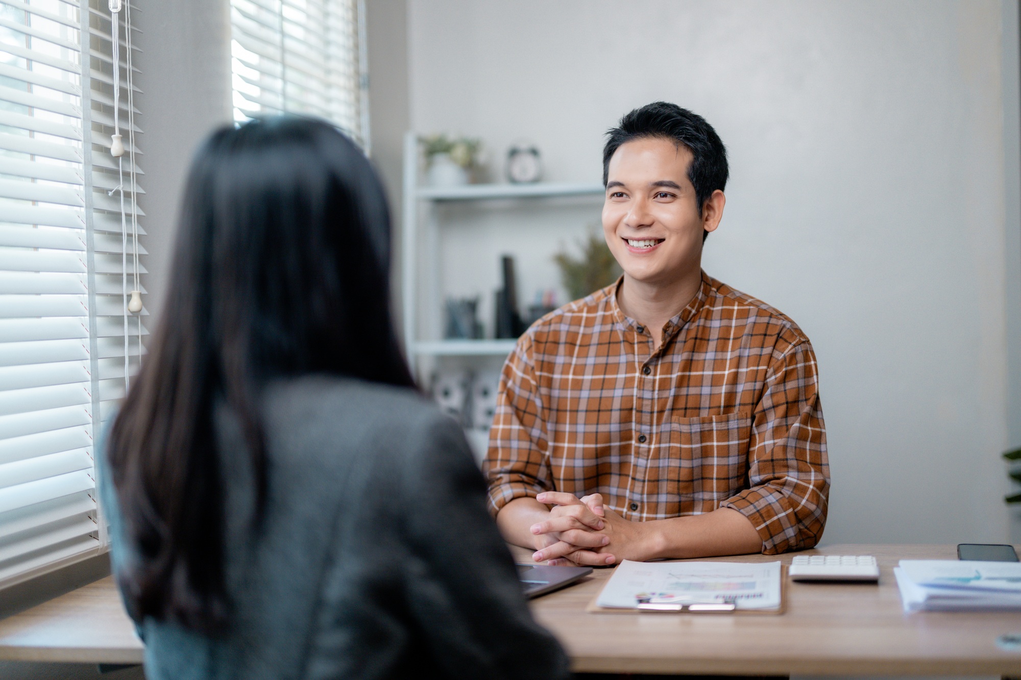 Businessman smiling during job interview with human resources manager in office