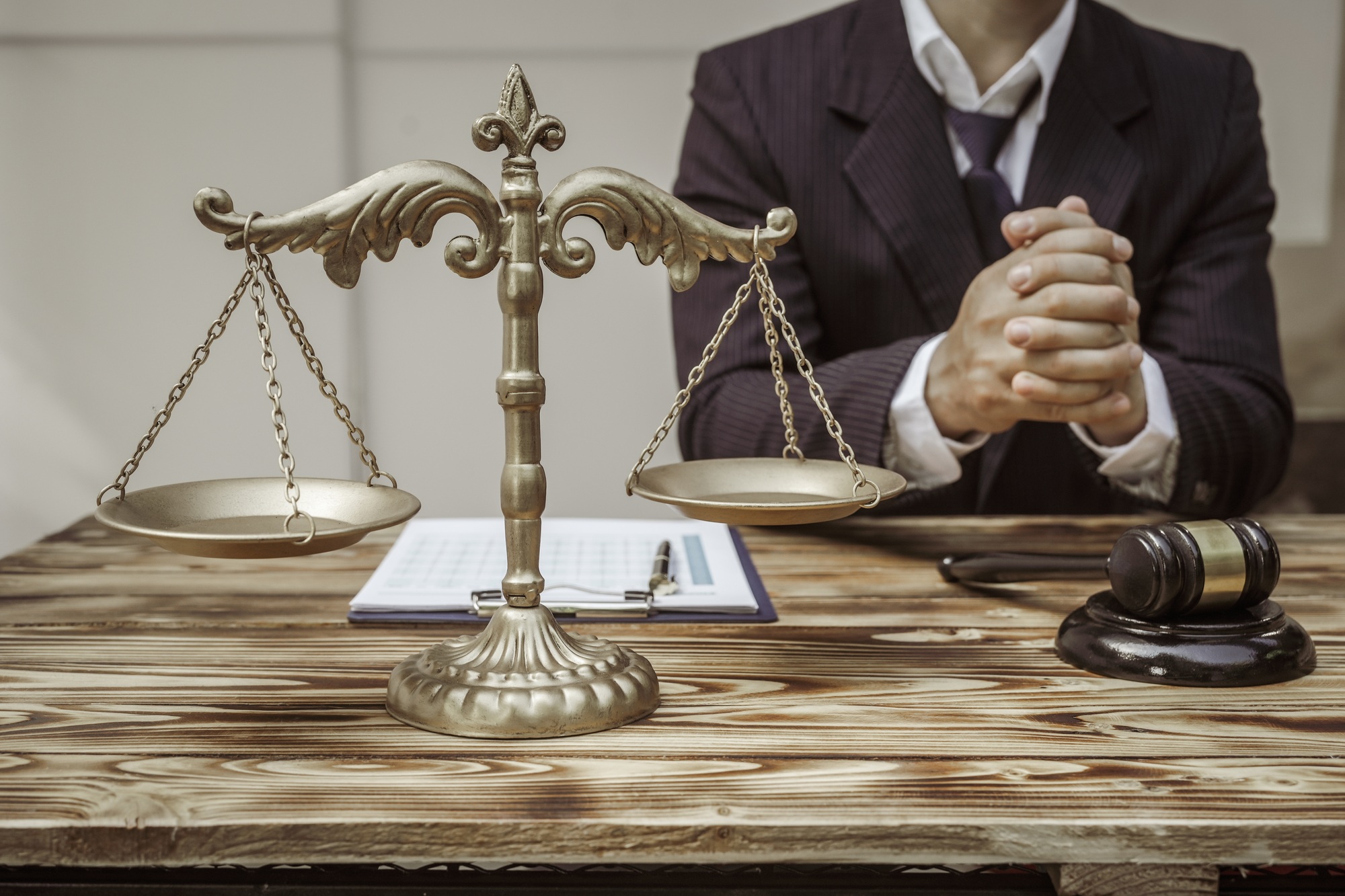 A businessman in a formal suit signs a contract, hands close up, suggesting possible bribery